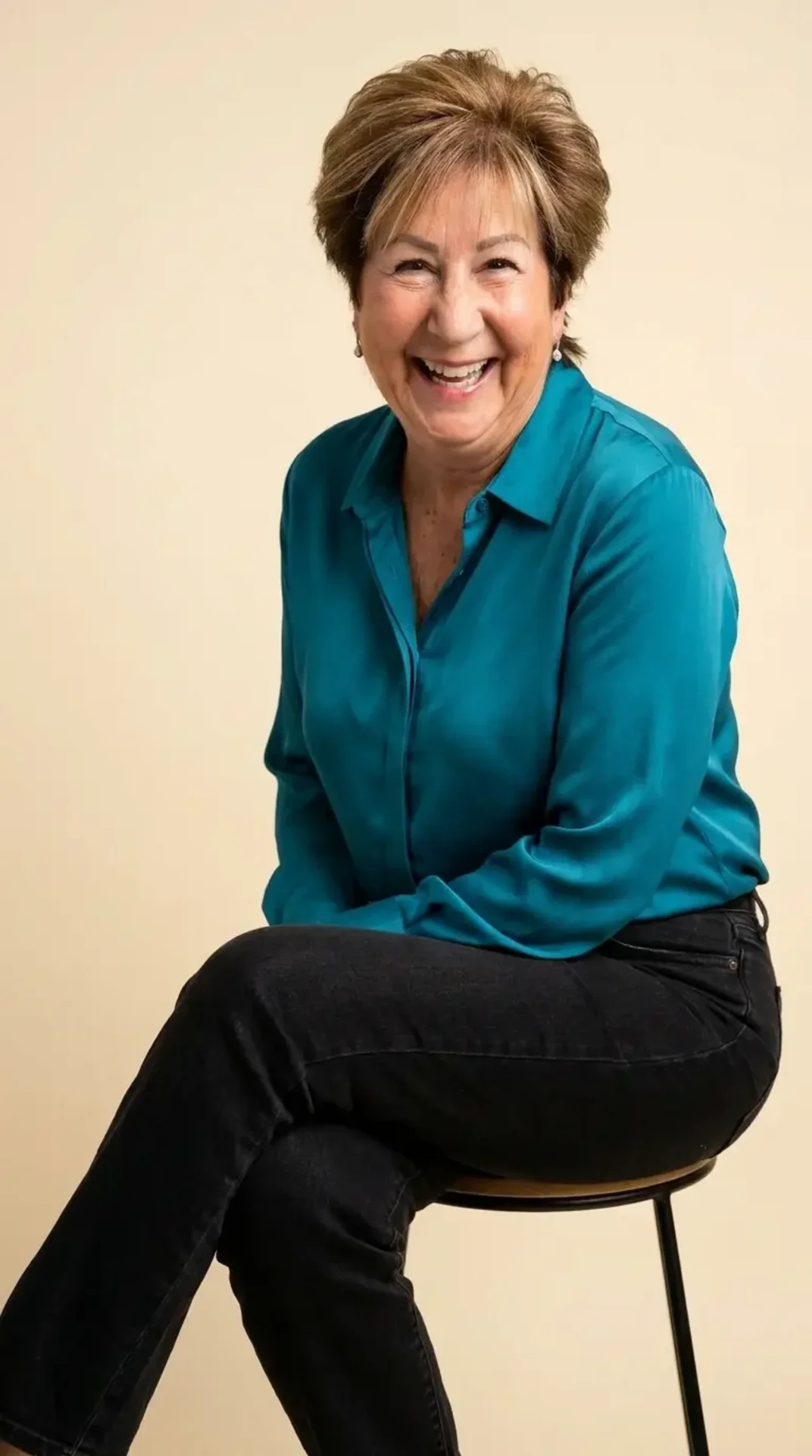 AI brand portrait of Ellen seated on a stool against a warm cream backdrop